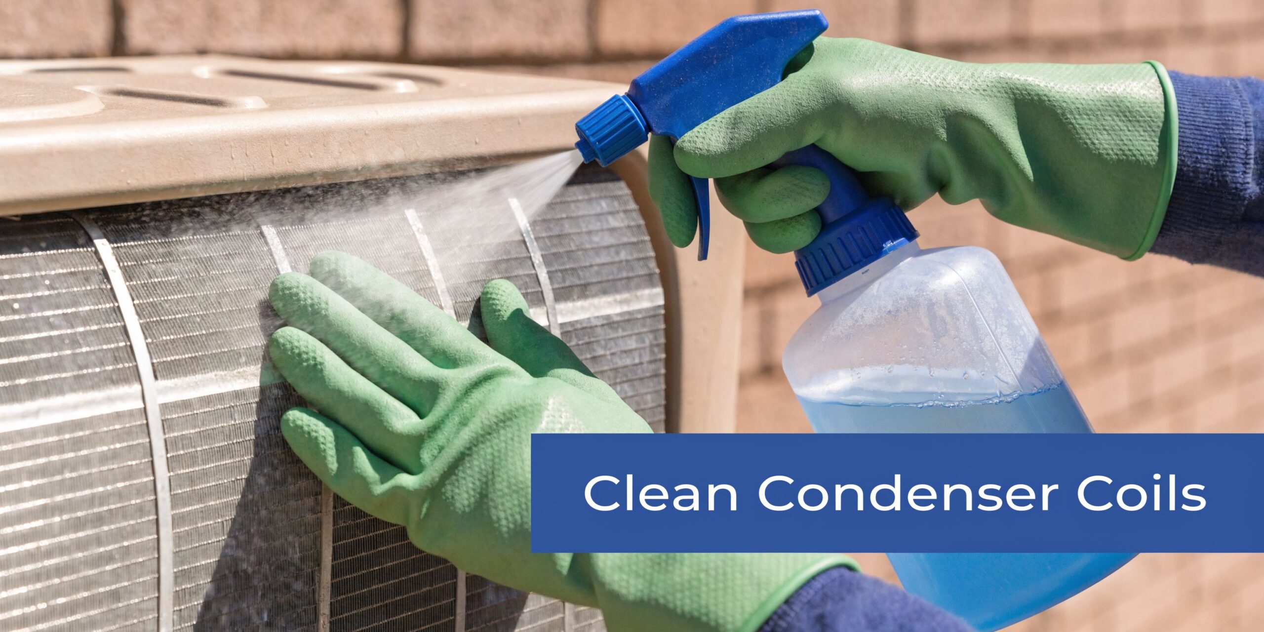 A person wearing protective green gloves uses a blue spray bottle to clean air conditioner condenser coils.